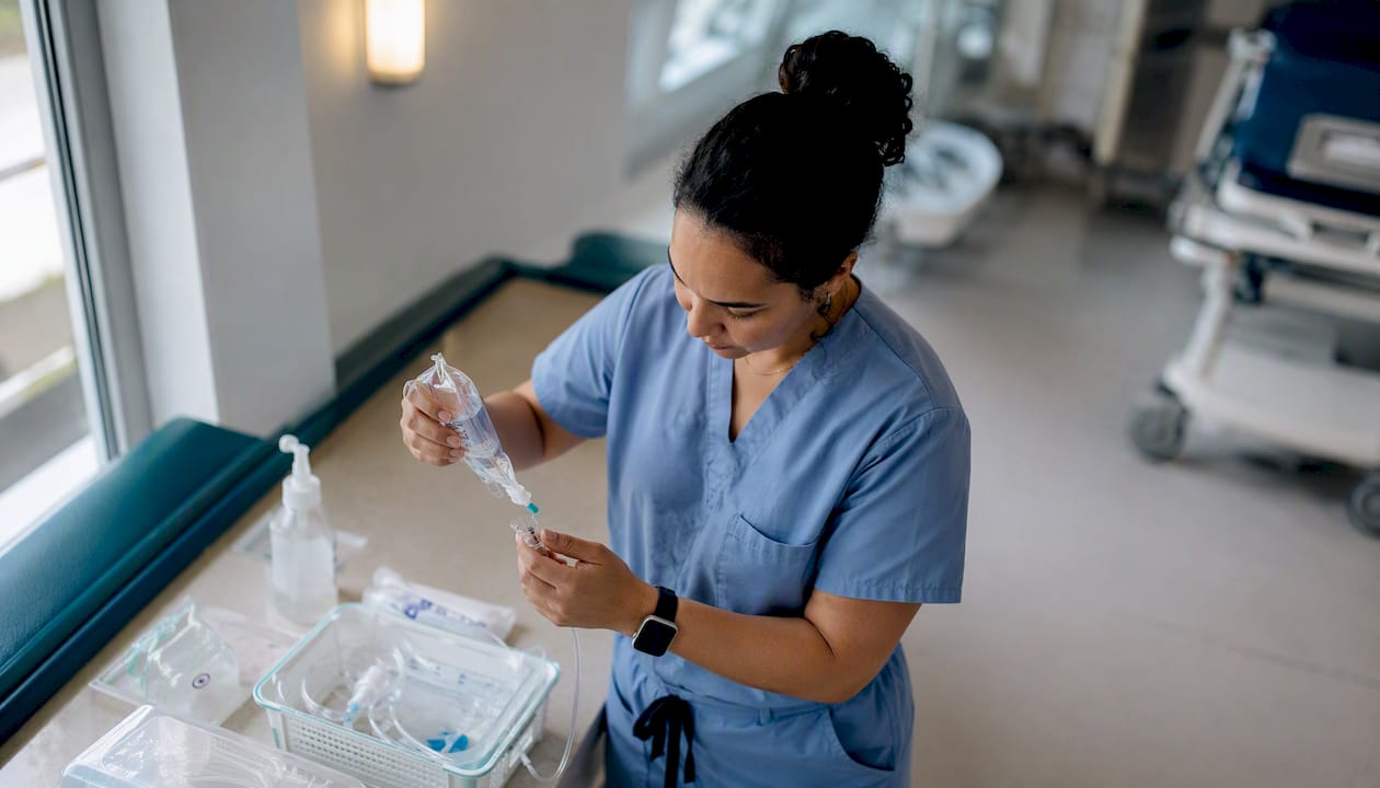 Una enfermera alista cuidadosamente el material médico antes de atender a los pacientes.