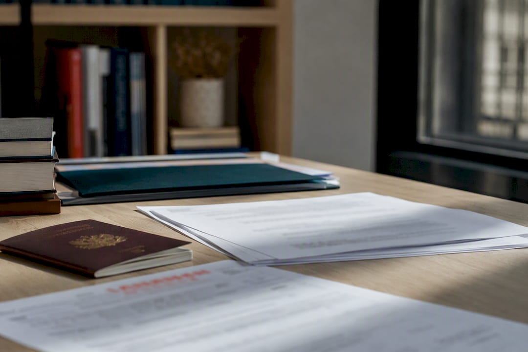 Documentos de residencia española sobre una superficie color turquesa