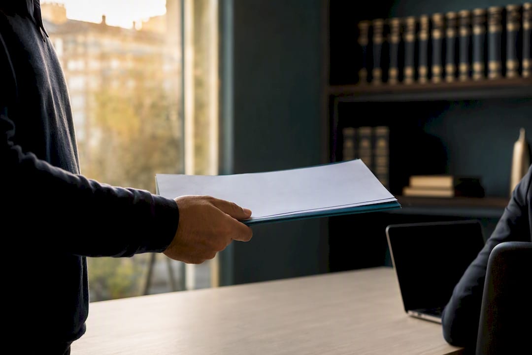 Mano entregando documentos en la oficina de extranjería