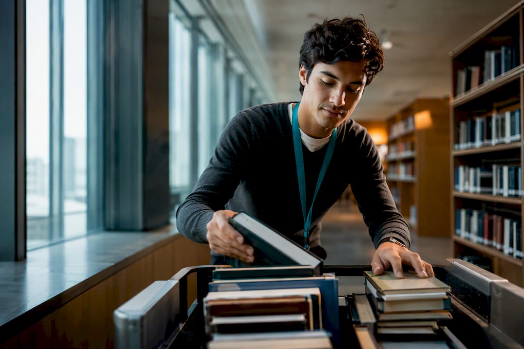 Estudiante extranjero trabajando en la biblioteca de la universidad